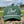 Green cap with 'Dad Country Club' text on a stone surface with a blurred natural background