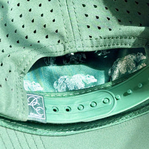 Close-up of a green cap with a brand logo on the snapback.